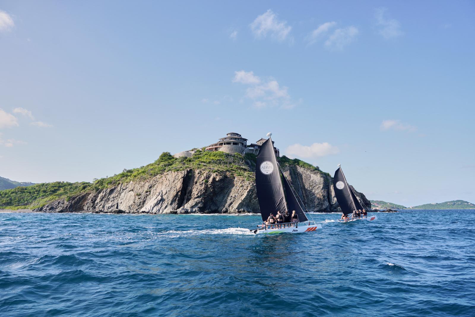 Aerial-branded catamarans sailing past Buck Island